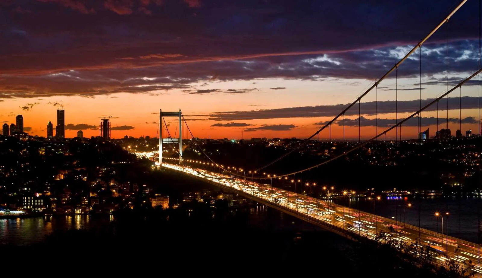 Gün batımında Boğaz Köprüsü ve İstanbul silüeti.