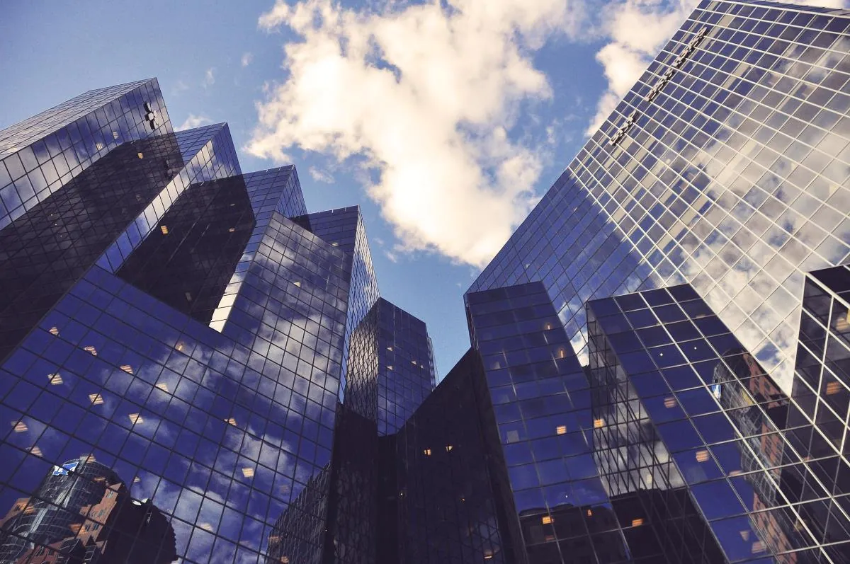 Glass office towers seen from street level against the sky.