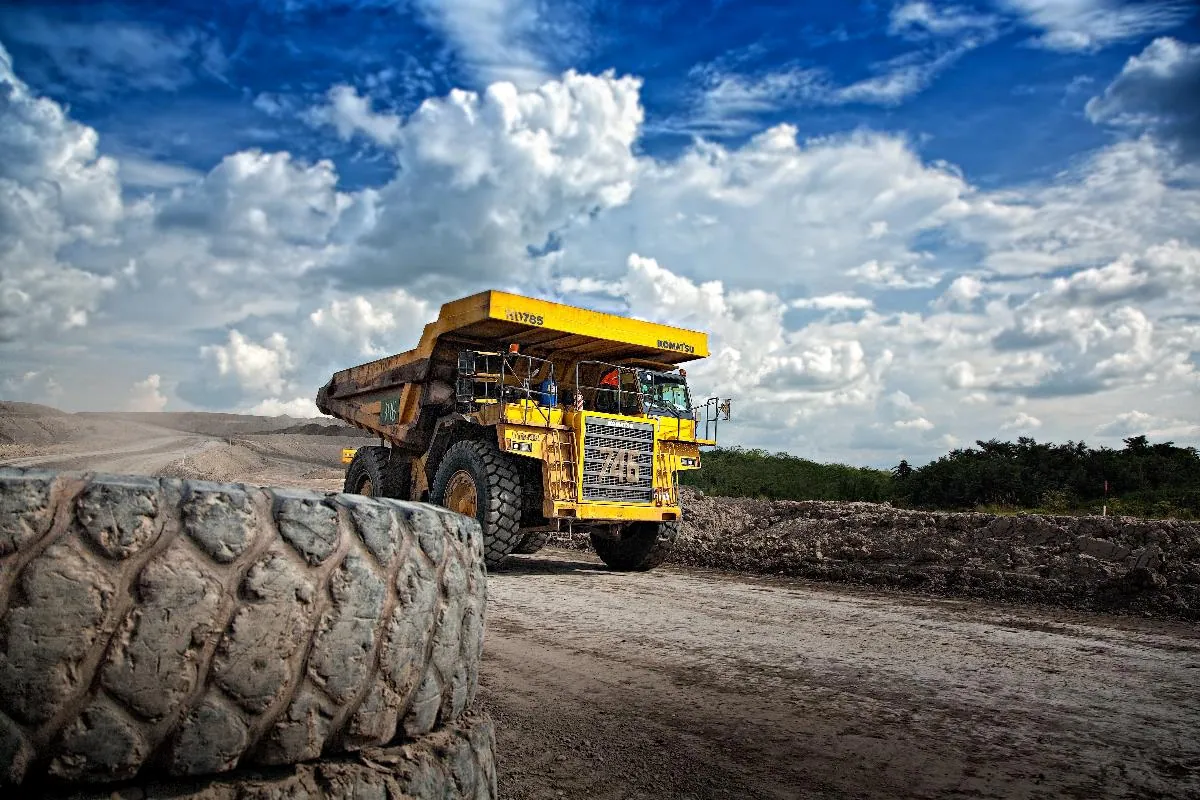 A large yellow mining haul truck on a dirt road.