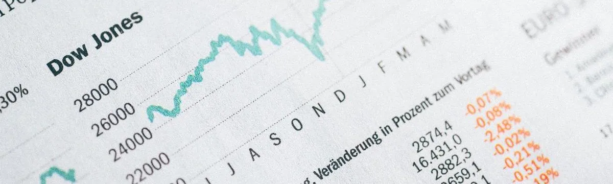 A newspaper financial page showing a Dow Jones index chart and share price tables.