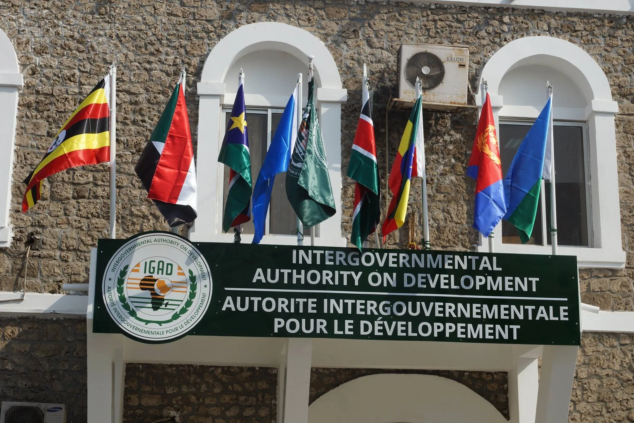 Le siège de l'IGAD à Djibouti, avec les drapeaux des États membres flottant au-dessus de l'enseigne d'entrée.