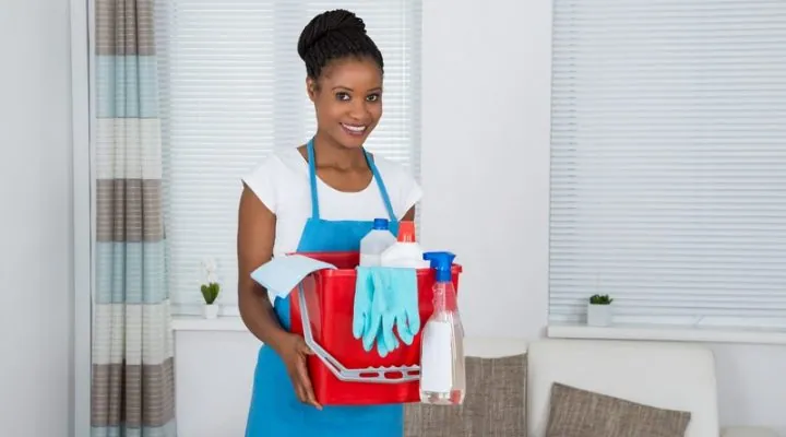 50691540 – smiling african woman holding basket with cleaning equipment 50691540 - smiling african woman holding basket with cleaning equipment